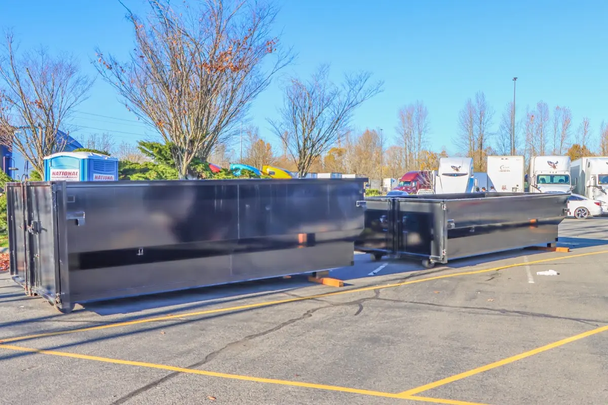 Professional dumpster rental service with roll-off container on residential driveway in Apex